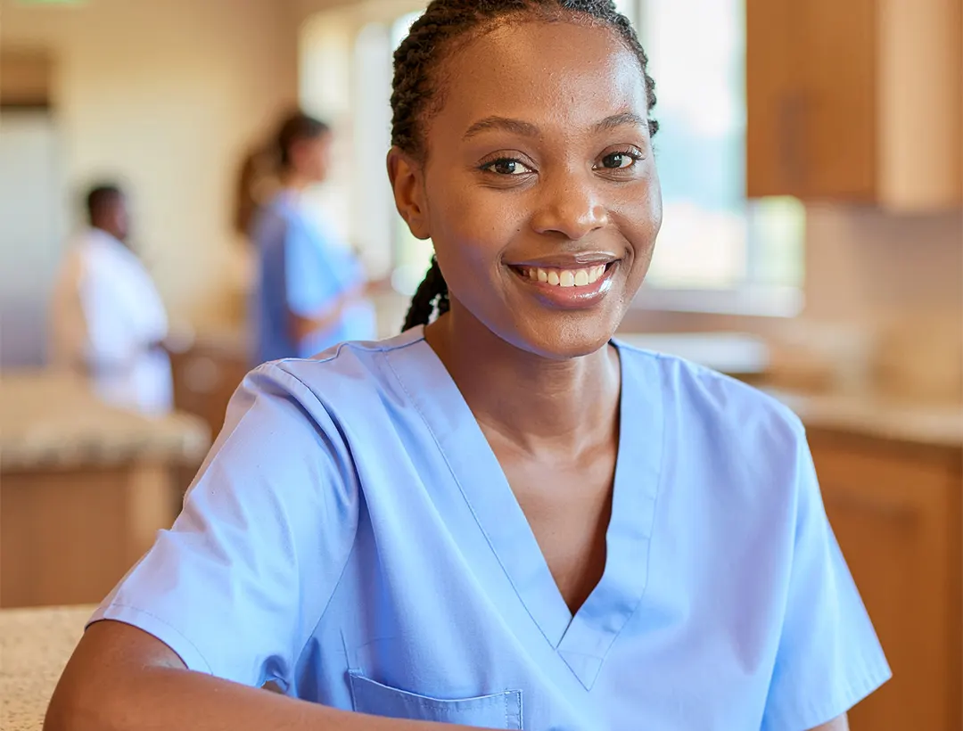 A nurse in blue uniform in a hospital corridor